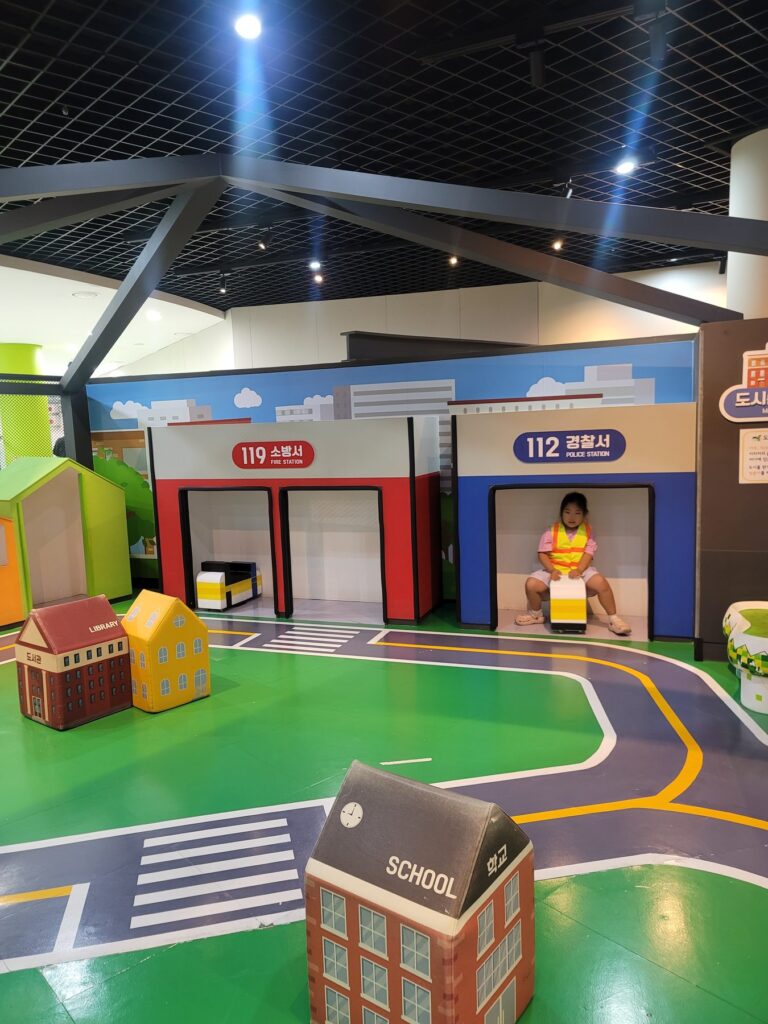 Child in a safety vest at the 119 fire station and 112 police station role-play area