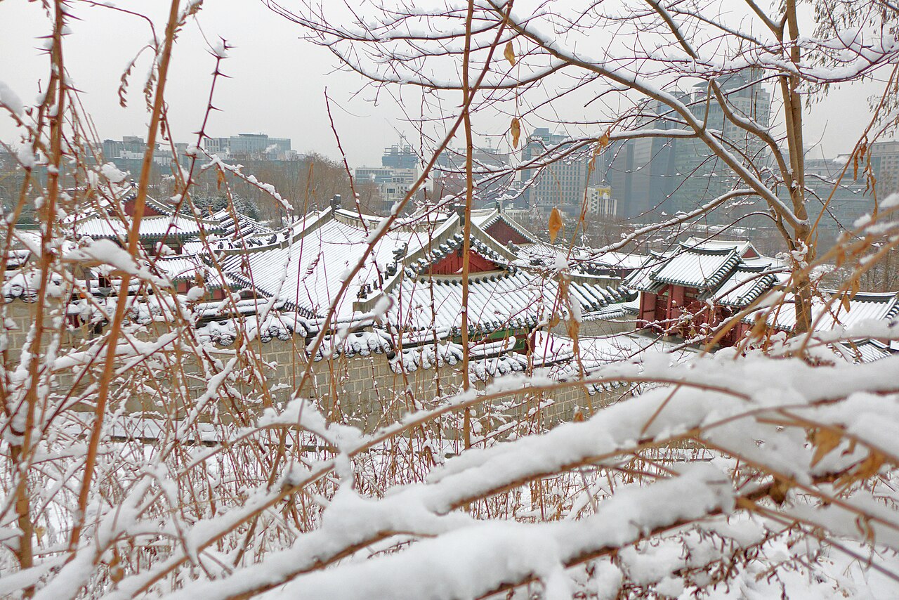 Snowy view across the restored grounds of Gyeonghuigung Palace in Seoul
